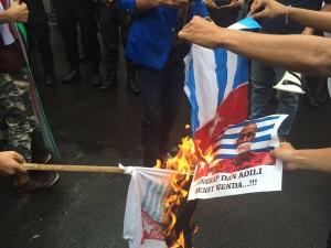 Aksi Unjukrasa di depan dubes Inggris dengan membakar bendera